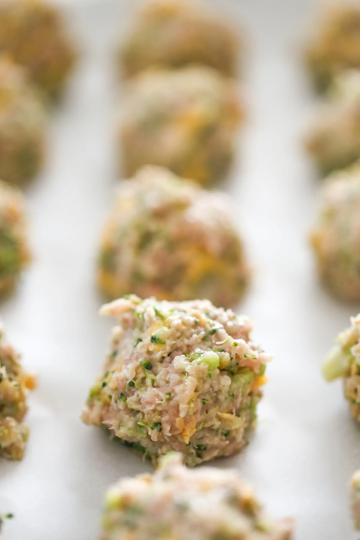 Close up of uncooked turkey meatball on baking sheet waiting to be baked