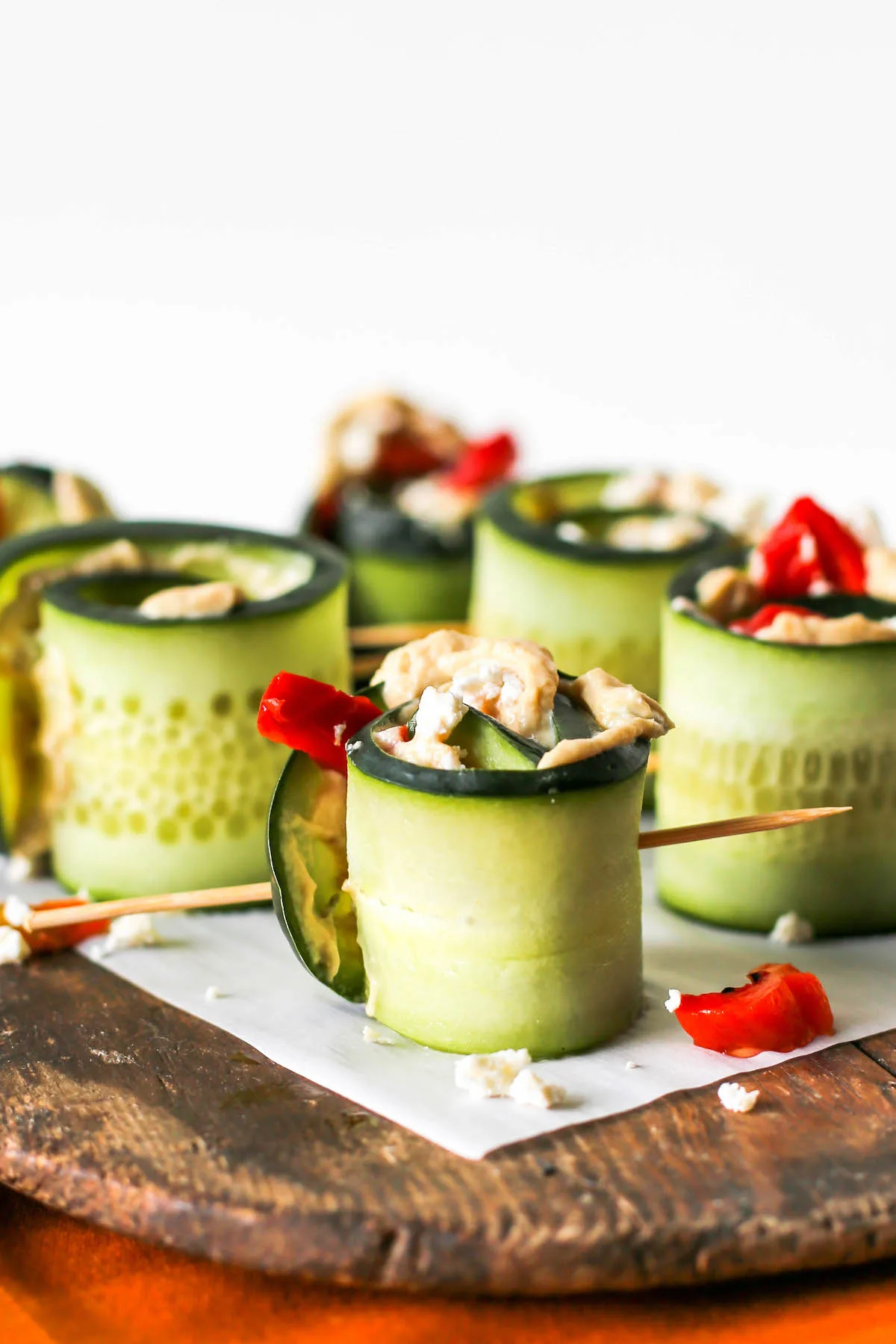 Cucumber Hummus Roll Ups Appetizer on wooden serving board