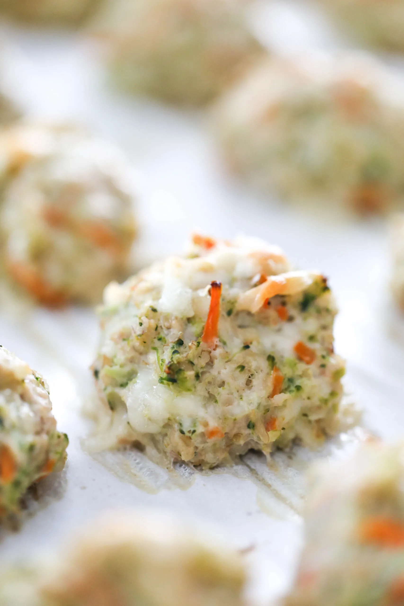 Close up of cooked chicken meatball on baking sheet